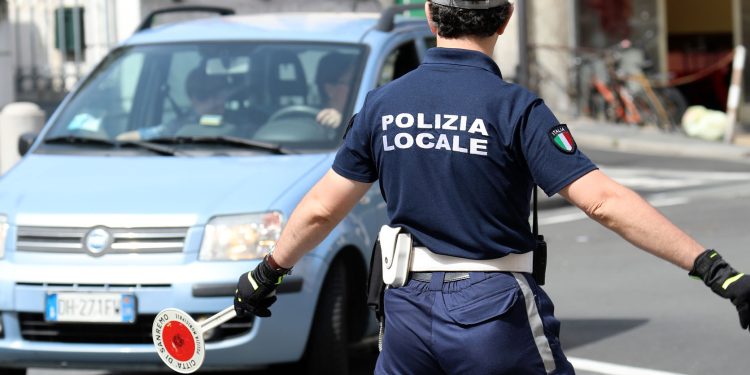 San Remo, Italy - June 10, 2018: Italian Policeman (Polizia Locale) in Uniform Controlling Road Traffic in The City Center of San Remo, Liguria, Italy