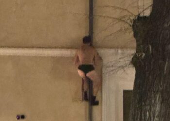 Uomo in mutande scala la grondaia di un palazzo in centro: indignazione sui social